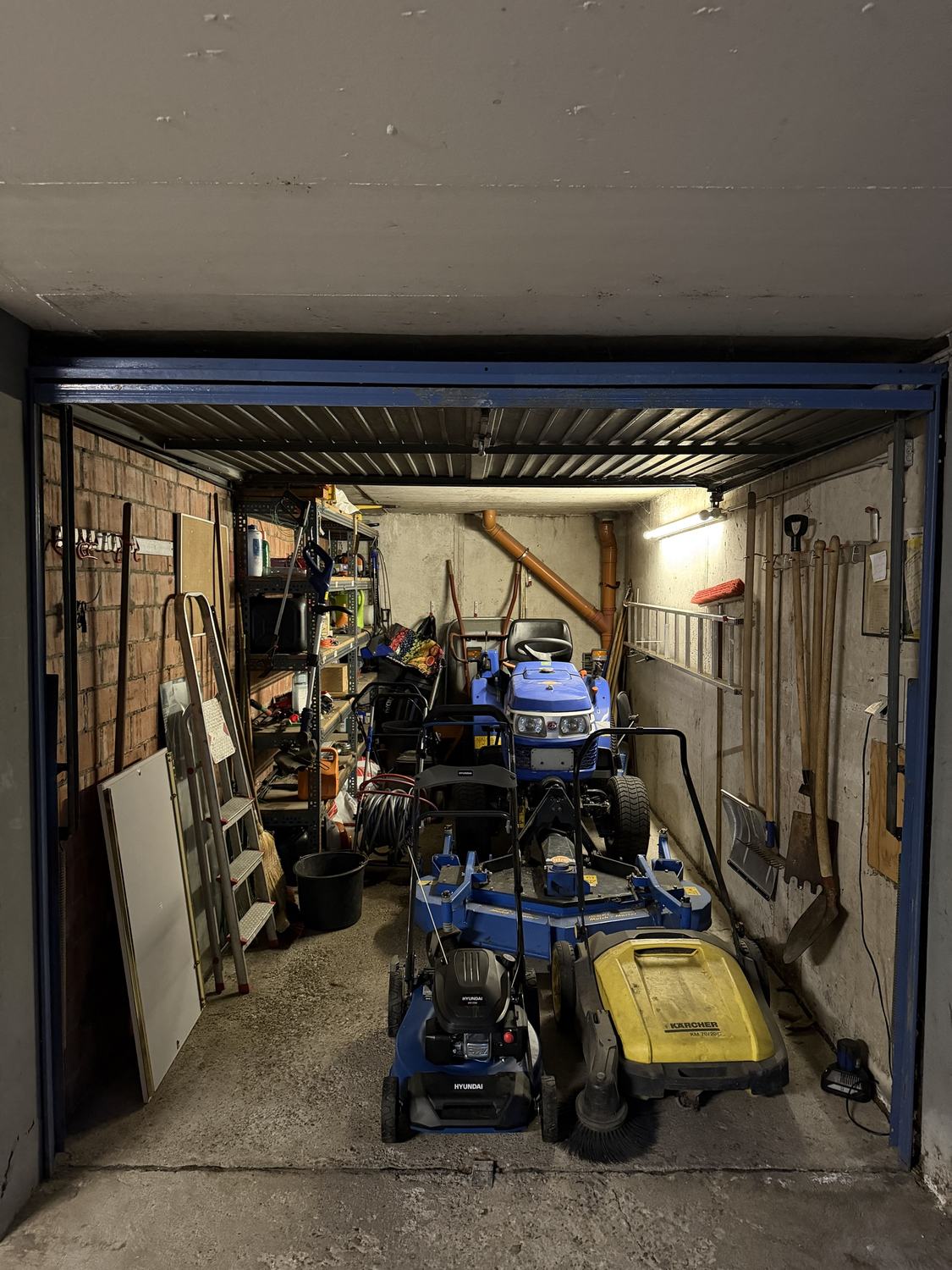 Geräteraum mit Traktor, Mäher und Werkzeug